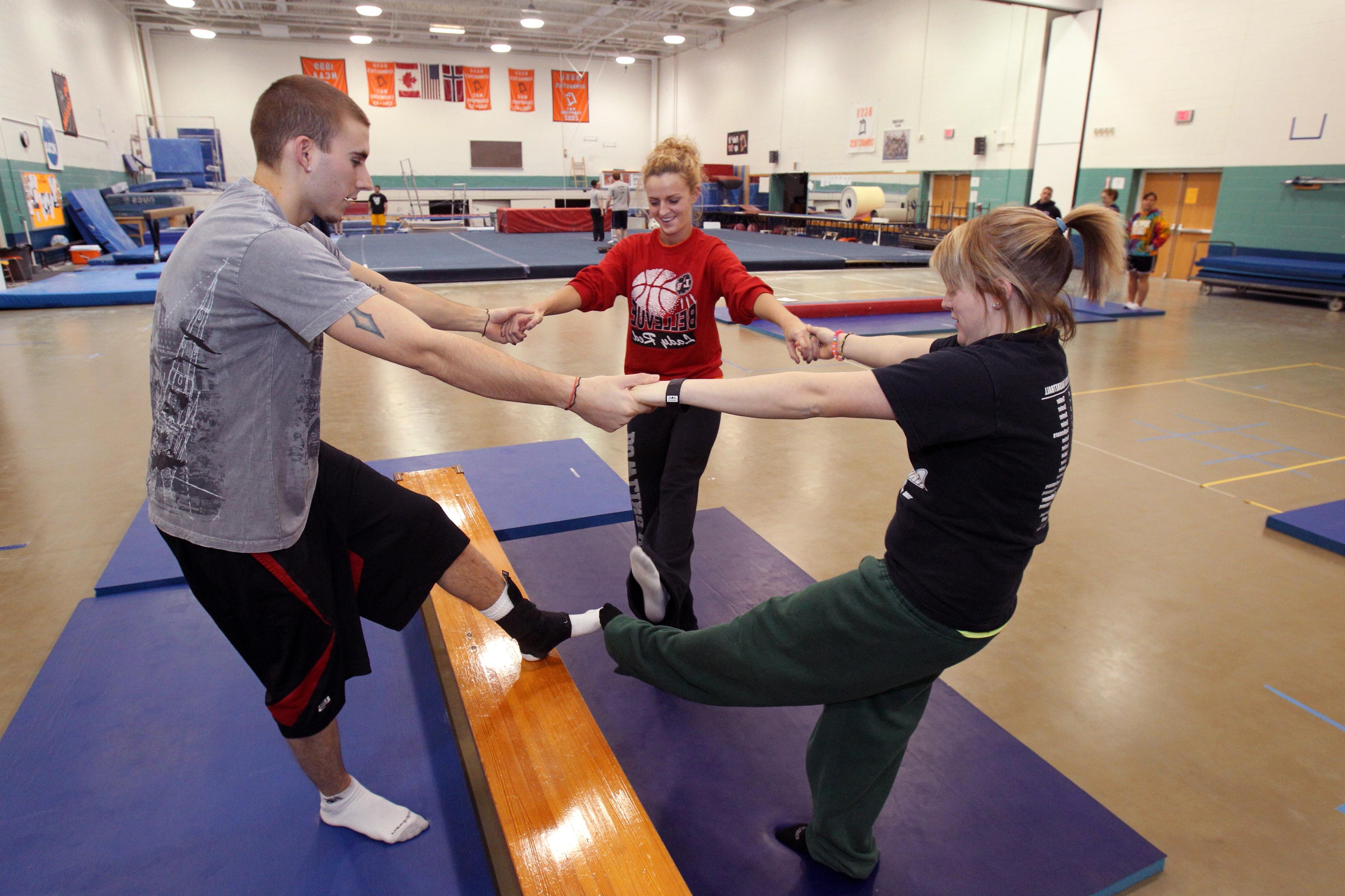 三名BGSU运动机能学硕士学生在俄亥俄州校园的一个专门的健身中心练习力量练习.