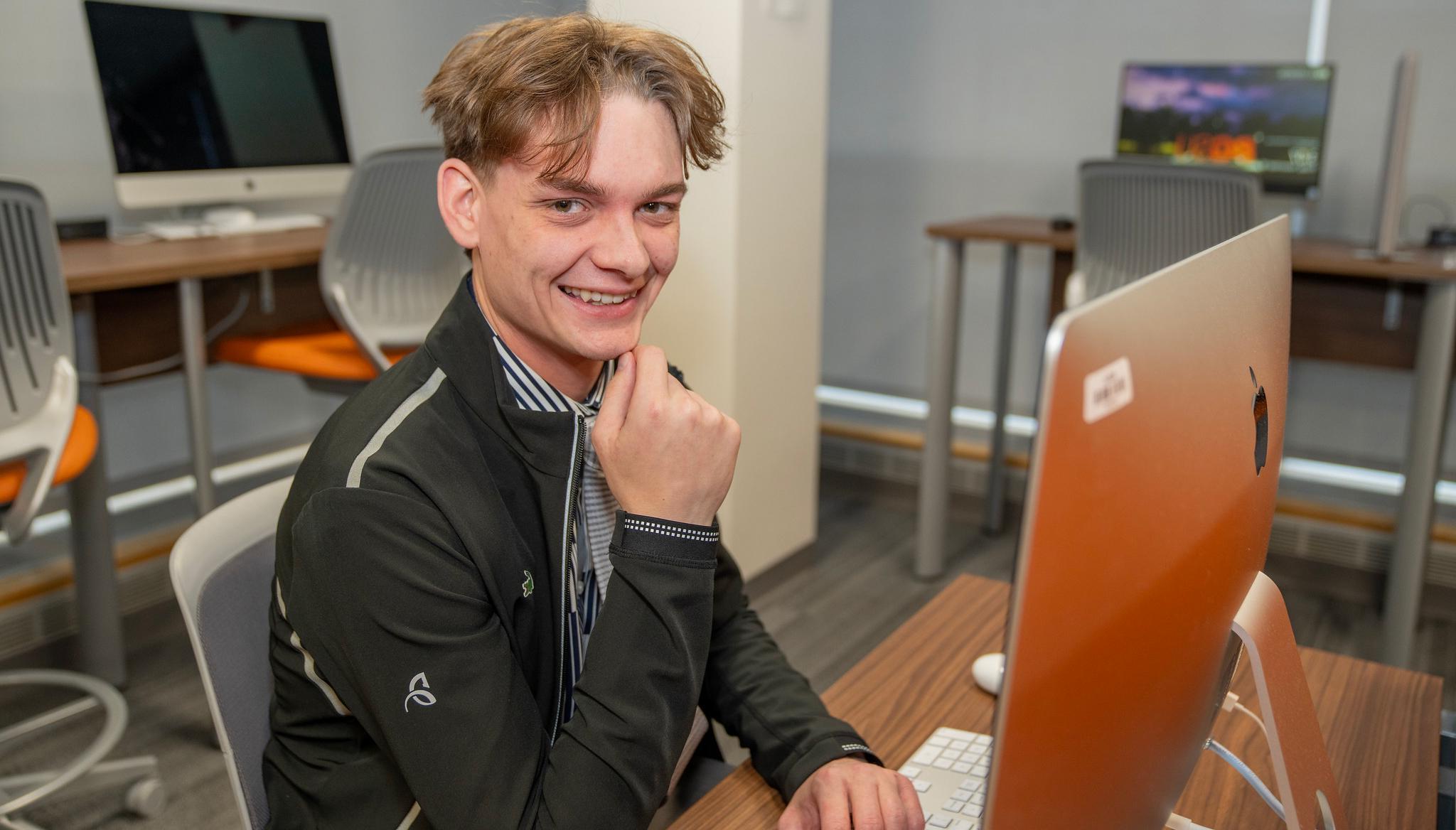 一位计算机网络专业的学生在计算机实验室工作时露出微笑 
